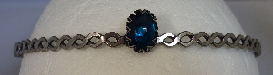 Silver-tone braid band with oval blue center stone