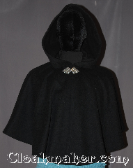 Cloak:3319, Cloak Style:Shaped Shoulder-Short, Cloak Color:Black, Fiber / Weave:100% Wool Melton, Cloak Clasp:Triple Medallion, Hood Lining:Unlined, Back Length:23.5", Neck Length:19.75", Seasons:Winter, Southern Winter, Fall, Spring, Note:This youth short capelet is a perfect child's<br>first cloak that will grow<br>with your child for years to come.<br>Short enough for play and made of a rugged, warm<br>black 100% wool and adorned with<br>an elegant pewter triple medallion clasp.<br>Dry or spot clean only..