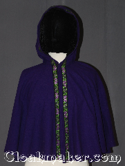Cloak:3536, Cloak Style:Full Circle Capelet<br>short/youth, Cloak Color:Purple with floral trim, Fiber / Weave:100% Wool, Cloak Clasp:Hidden hook and eye, Hood Lining:Black crushed velvet<br>with floral trim, Back Length:21", Neck Length:17.5", Seasons:Fall, Spring, Note:This beautiful child's cloak is a one of a kind piece<br>Made from discontinued materials this small<br>purple capelet has a lovely purple and green<br>on black floral trim around the front<br>and a black crushed velvet hood.<br>Spot or dry clean only.<br>Can not be reproduced..