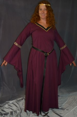 Gown ID:G622, Gown Color:Burgundy, Style:12th Century, Sleeve:Long drop sleeve, Trim:Persian Style trim at bicep, black facing with gold braid on neck, Neckline Type:V-Neck, Fabric:95% Cotton, 5% lycra, Sleeve Length:32.5", Back Length:55.5".