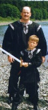 A man and a child display a pair of black poet pirate shirts or tunics.